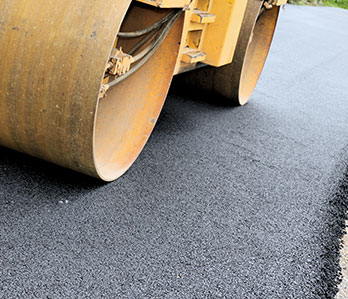 A roller laying asphalt on a road.