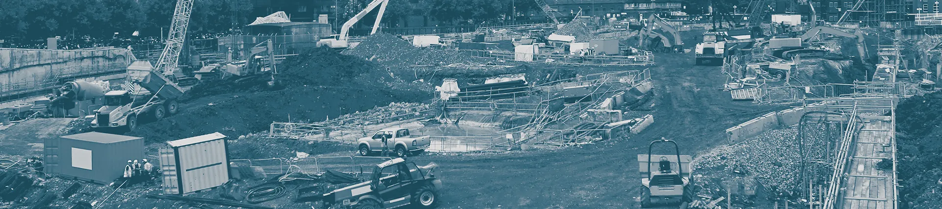 A photo of a construction site with cranes in the background.