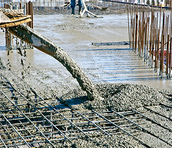 A machine pouring cement into a concrete slab.